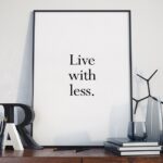 Live with less - plakat minimalistyczny w ramie, wymiary - 70cm x 100cm, wersja - białe napisy + czarne tło, kolor ramki - czarny