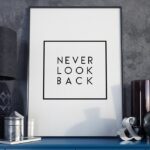 Never look back - plakat motywacyjny w ramie, wymiary - 60cm x 90cm, wersja - białe napisy + czarne tło, kolor ramki - biały