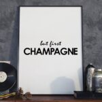 But first champagne - designerski plakat w ramie, wymiary - 18cm x 24cm, wersja - białe napisy + czarne tło, kolor ramki - czarny